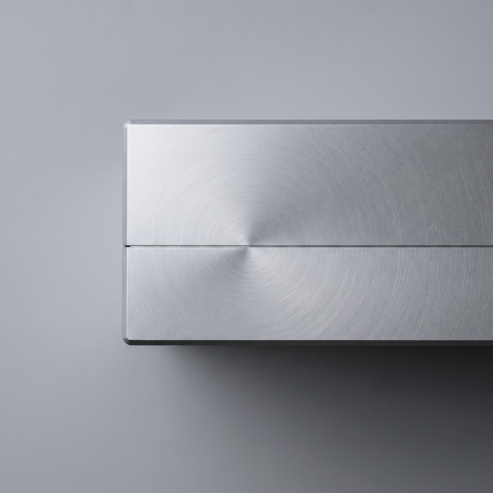 Two metal parts meeting along a single hairline seam, fine concentric tool marks across both faces.