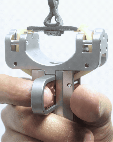 Looping close view of the fork head: the bands, the roller bearings and a thumb on the trigger latch