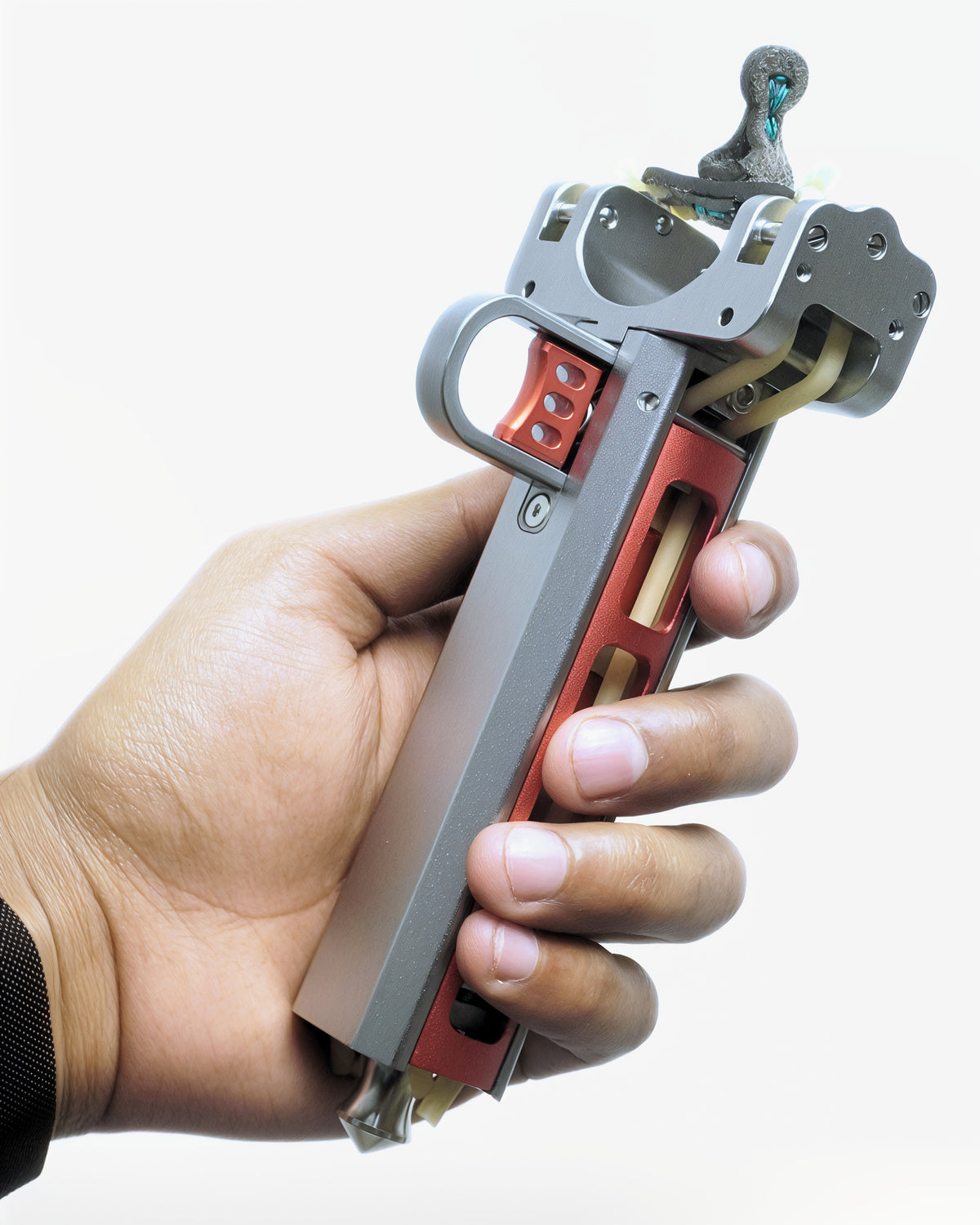 VANTA V10 angled in the hand on a white background, showing the thumb loop, the trigger latch and the red magazine channel