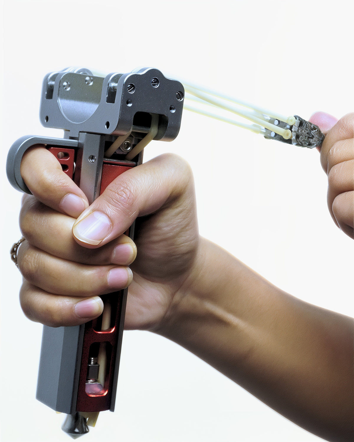 Two hands drawing the bands back, the full frame and magazine channel visible against a white background